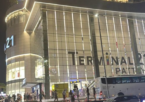 חזית מרכז הקניות טרמינל 21 פטאיה, בניין מודרני בסגנון נמל תעופה עם מטוס אמיתי בחזית ורציף דמוי מסלול המראה